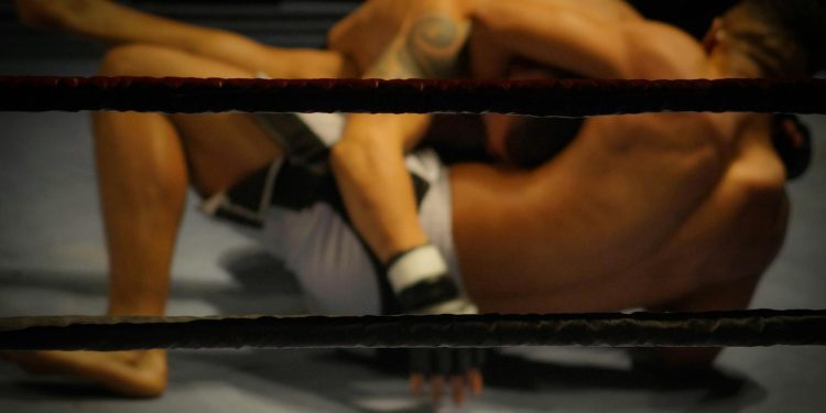 Two athletes engaged in a dynamic wrestling match within the ring.