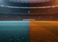 Floodlit stadium pitch at golden hour with Argentina and Austria colour-coded lighting, no players visible.