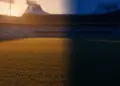 Empty floodlit football pitch at golden hour, split colour palette of light blue-white and deep blue-yellow, packed stadium in soft focus background.