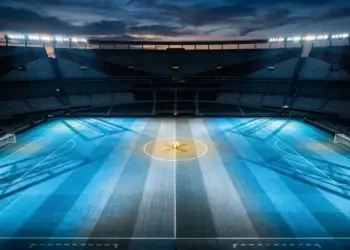 Floodlit stadium pitch in Argentina blue and white with ball at centre spot, evening atmosphere.