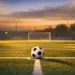 Floodlit football pitch at dusk with match ball on centre spot, dramatic shadows and evening kickoff atmosphere.