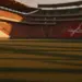 Floodlit stadium at golden hour showing packed stands with Côte d'Ivoire and Norway flag colours, empty pitch with dramatic shadows.