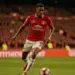 Brazilian midfielder driving forward with ball in Manchester United kit at packed Premier League stadium