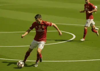 Manchester United midfielder controlling the ball in deep midfield position with teammate advancing into space