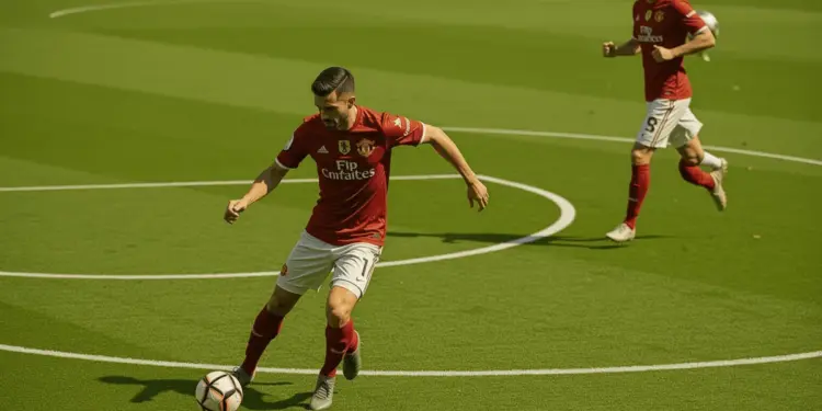 Manchester United midfielder controlling the ball in deep midfield position with teammate advancing into space