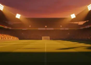 Floodlit stadium with packed stands at sunset, dramatic shadows on pitch, English and Ghanaian colour palette lighting.