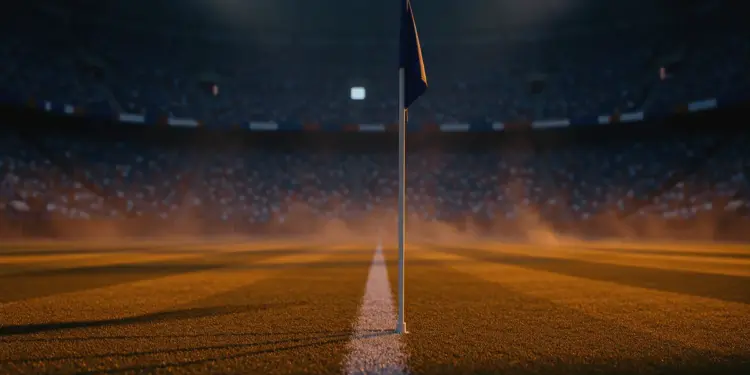 Empty floodlit stadium pitch at dusk with national flag colours in stands, shallow depth of field, dramatic lighting.
