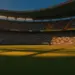 Floodlit stadium at golden hour with Mexican and Ecuadorian flag colours in crowded stands, dramatic shadows on pitch.