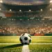 Floodlit football pitch with emerald and white stadium lighting, ball on centre spot, dramatic evening kickoff atmosphere.
