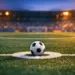 Floodlit football pitch at dusk with match ball on penalty spot, dramatic stadium shadows, cool-warm colour grade.
