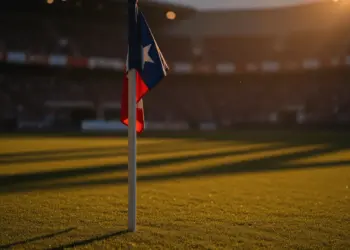 Floodlit stadium pitch at golden hour with dramatic shadows and flag-colour atmospheric lighting during World Cup group stage.