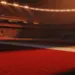Floodlit stadium at golden-hour with packed stands, dramatic shadows, and red-lit pitch—Portugal vs. Croatia knockout preview.