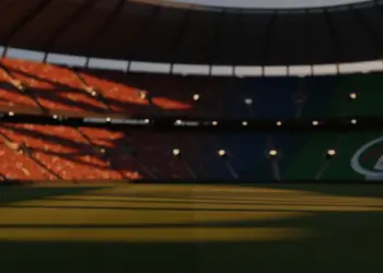 Empty floodlit stadium at dusk with dramatic shadows and packed stands, red-white and green-white national lighting tones.