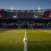 Floodlit stadium with coloured bunting and ball on pitch, pre-match atmosphere