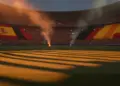 Floodlit empty stadium at dusk with Spanish and Belgian flag colours in stands, dramatic shadows, golden-hour lighting.