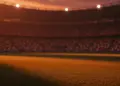 Floodlit stadium pitch at dusk with national colour stands, low-angle view, shadow patterns, no players.