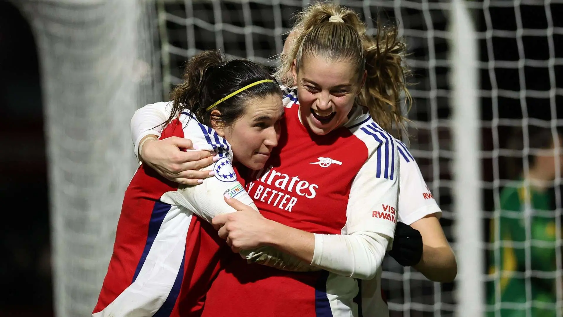 Alessia Russo and Mariona Caldentey hugging and celebrating in Arsenal women's football kits.
