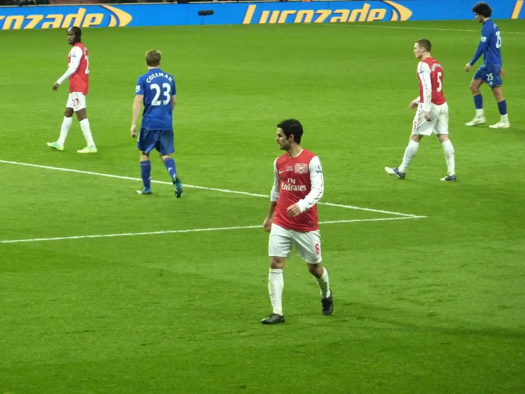 Mikel Arteta in an Arsenal kit standing on a football pitch during a match.