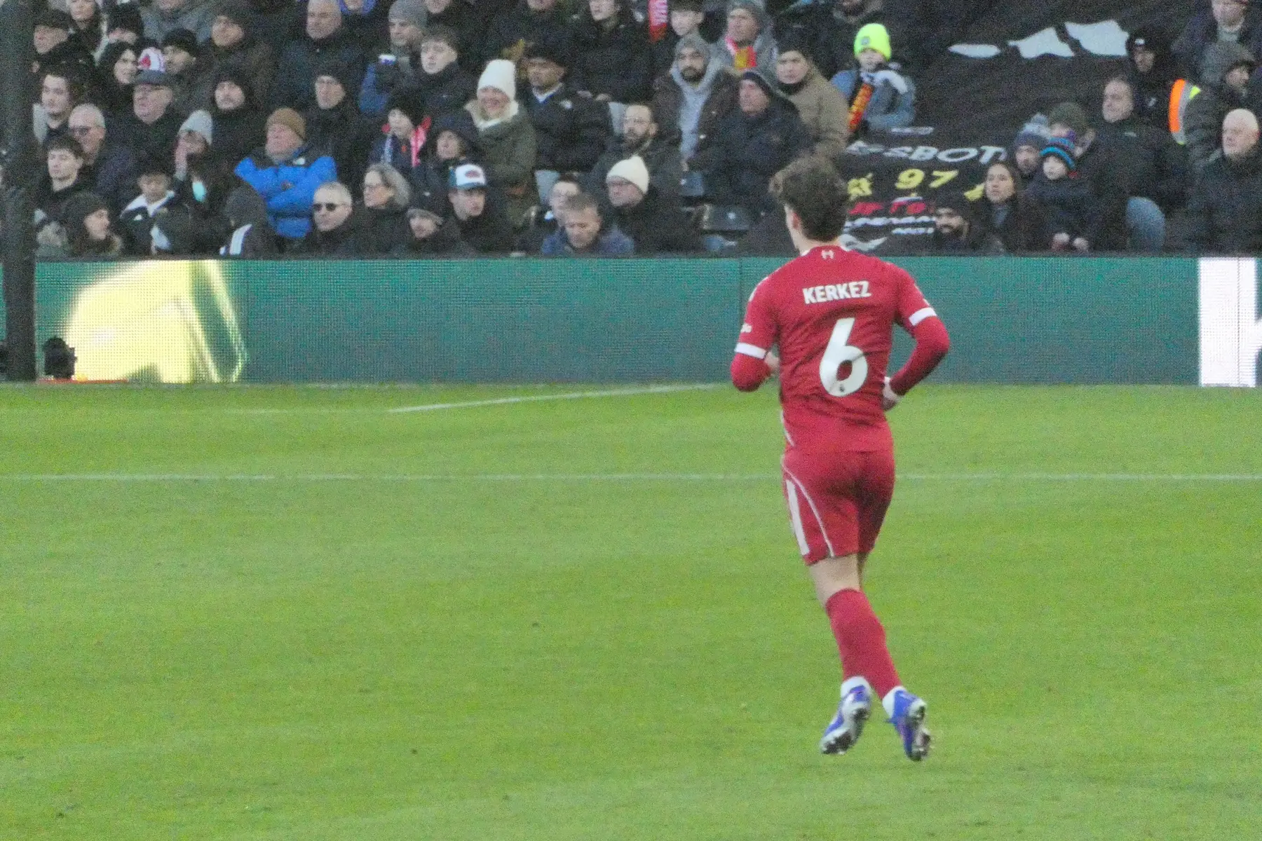 Milos Kerkez facing away from the camera, wearing a red football kit with number 6 and his name on the back.